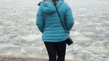 Lavanya standing in front of a freezing lake in Finland during her solo Finland tour from India.