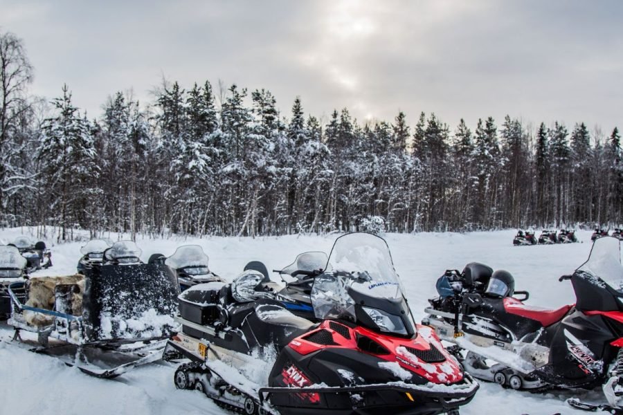 Snowmobile scooters lined up in snowy landscape