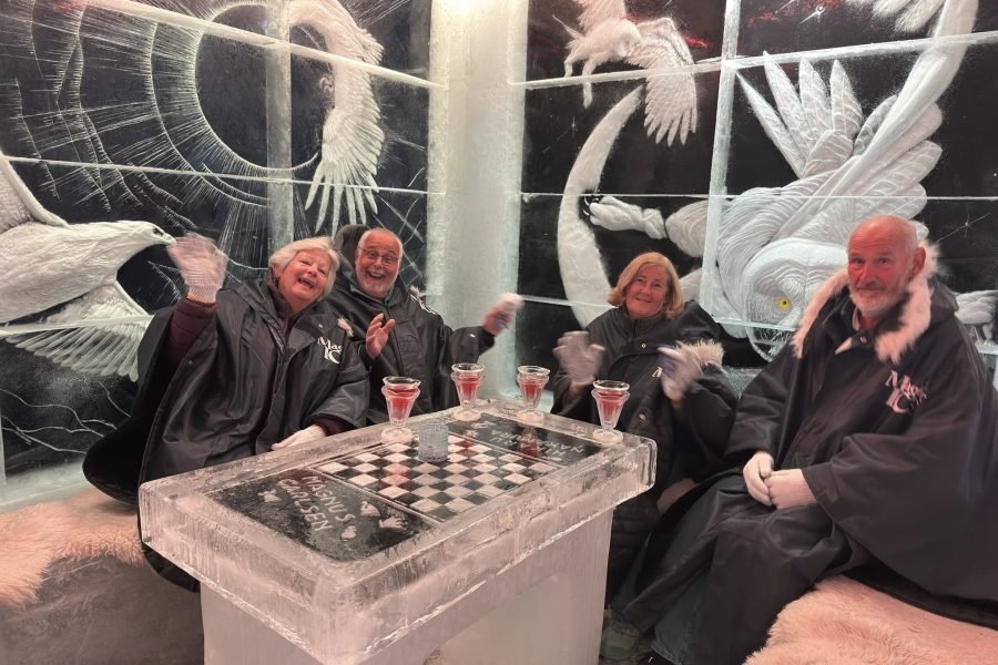 Tourist enjoying a drink at the Ice Bar in Tromsø during 13 Days Iceland, Norway and Finland tour package.