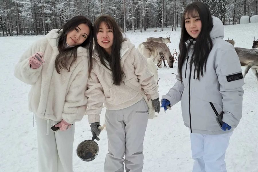 Three Hong Kong girls at a reindeer farm during their 8 days Finland tour from Hong Kong