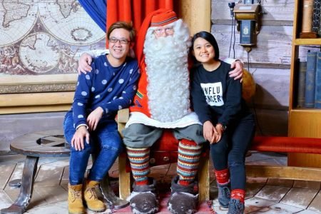 Couple traveler posing at Santa Claus Village in Finland during a winter tour