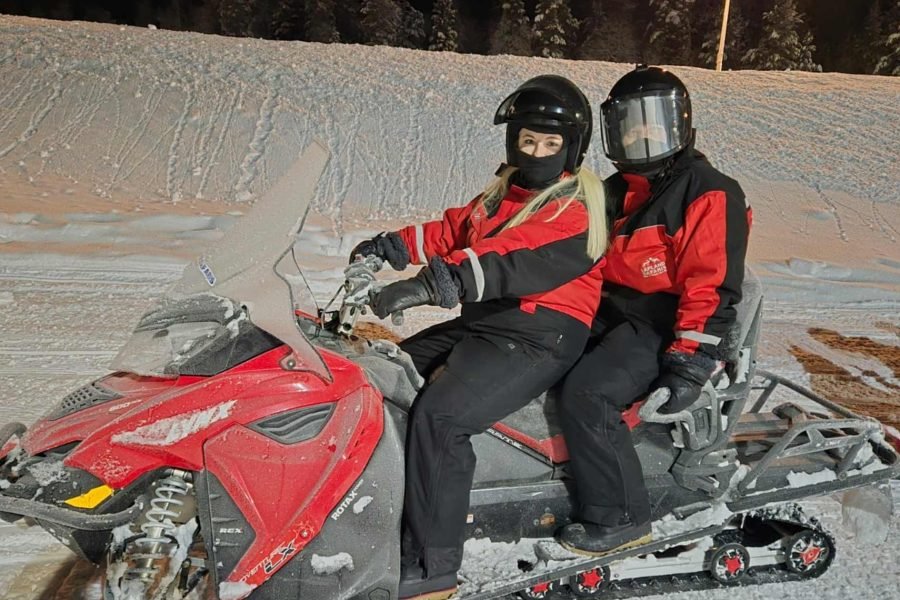 Travelers enjoying a snowmobile safari through the snowy landscapes of Rovaniemi, Finland, as part of their 6 days Finland tour from Singapore.