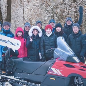 Travelers from Hong Kong posing after a thrilling snowmobile safari during their 15 days Finland tour from Hong Kong