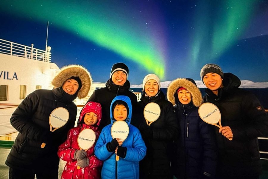Asian travelers aboard Havila cruise witnessing the Northern Lights during the 8 days Rovaniemi, Levi, Kirkenes & Tromso tour