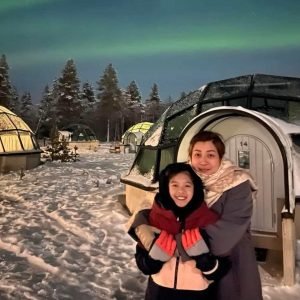Mother and son posing in front of glass igloos in Saariselka during 14 days Finland tour from Hong Kong