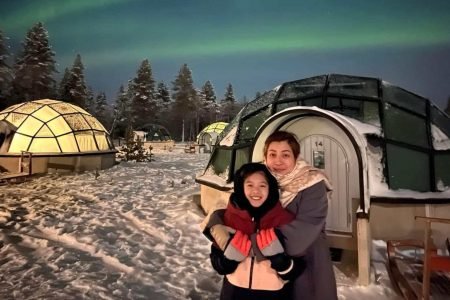 Mother and son posing in front of glass igloos in Saariselka during 14 days Finland tour from Hong Kong