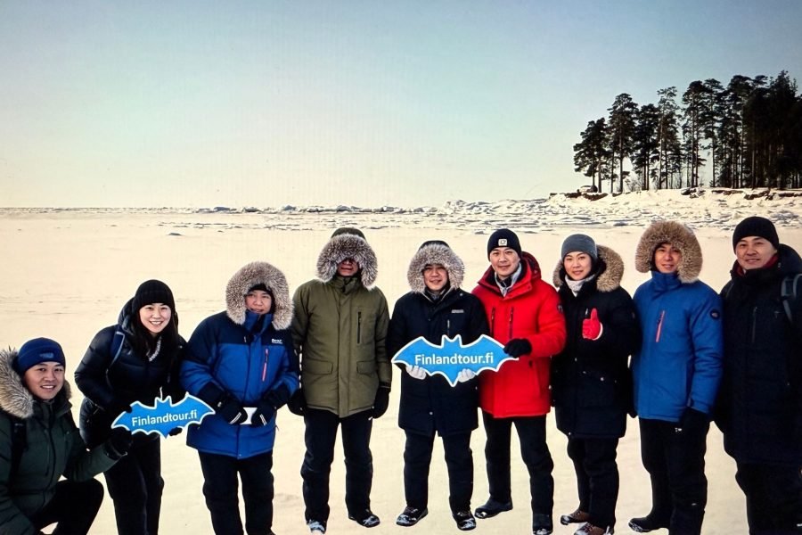 Travelers booked with finlandtour.fi posing in Ivalo’s snowy landscapes during the Best Finland & Norway tour with 2 days northern lights cruise to Tromso