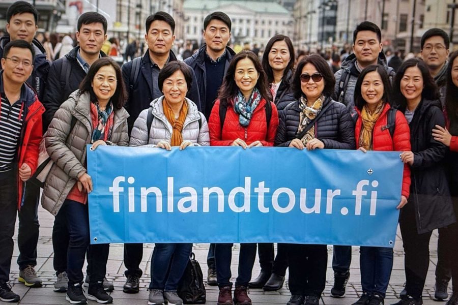 Group of Asian travelers posing cheerfully on a snowy street in Helsinki Central during their 11 days Finland tour from Singapore.